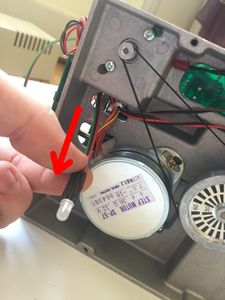 Flip the frame on its side and pull the LED and its three-wire ribbon cable. As previously explained, if you own a very old Disk ][, this hole in the frame will not exist and the LED and its cable will have to run on the upper face of the frame.