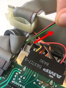 Pull gently on the three-wire ribbon cable of the two- color LED, so that the cable is not too loose inside the drive. If you own a very old Disk ][ drive without holes in the frame, your LED cable runs through the upper face of the frame. Then do not pull it too much.