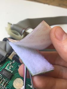 Take the rough part of the velcro and set it on the wooly part, at the rear of the Disk ][+ printed circuit board.